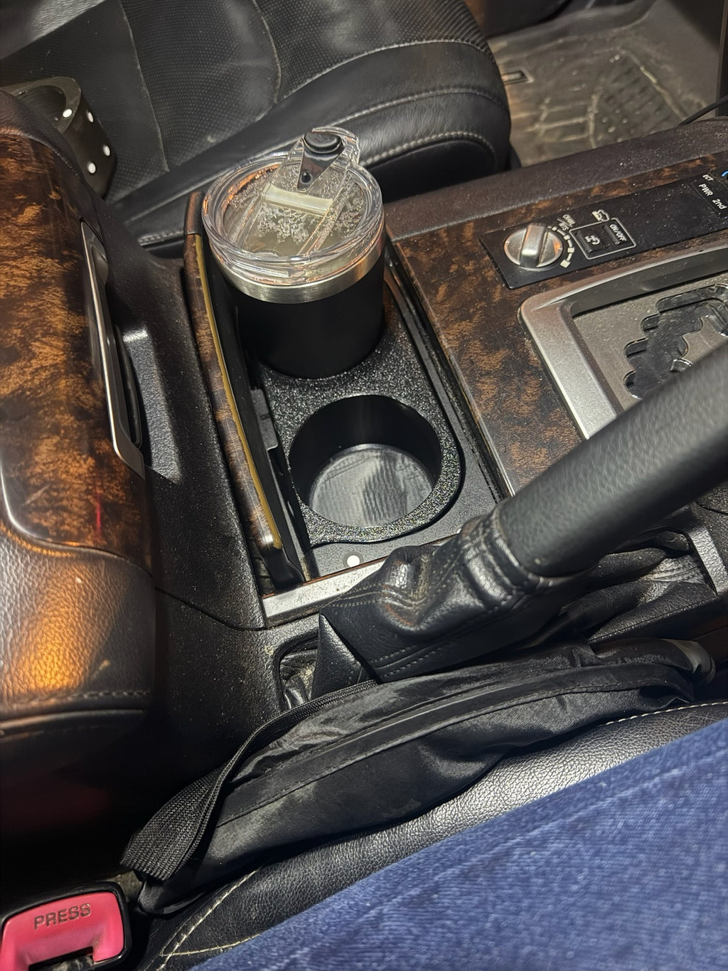 Cup holder insert installed in a woodgrain 200 Series centre console