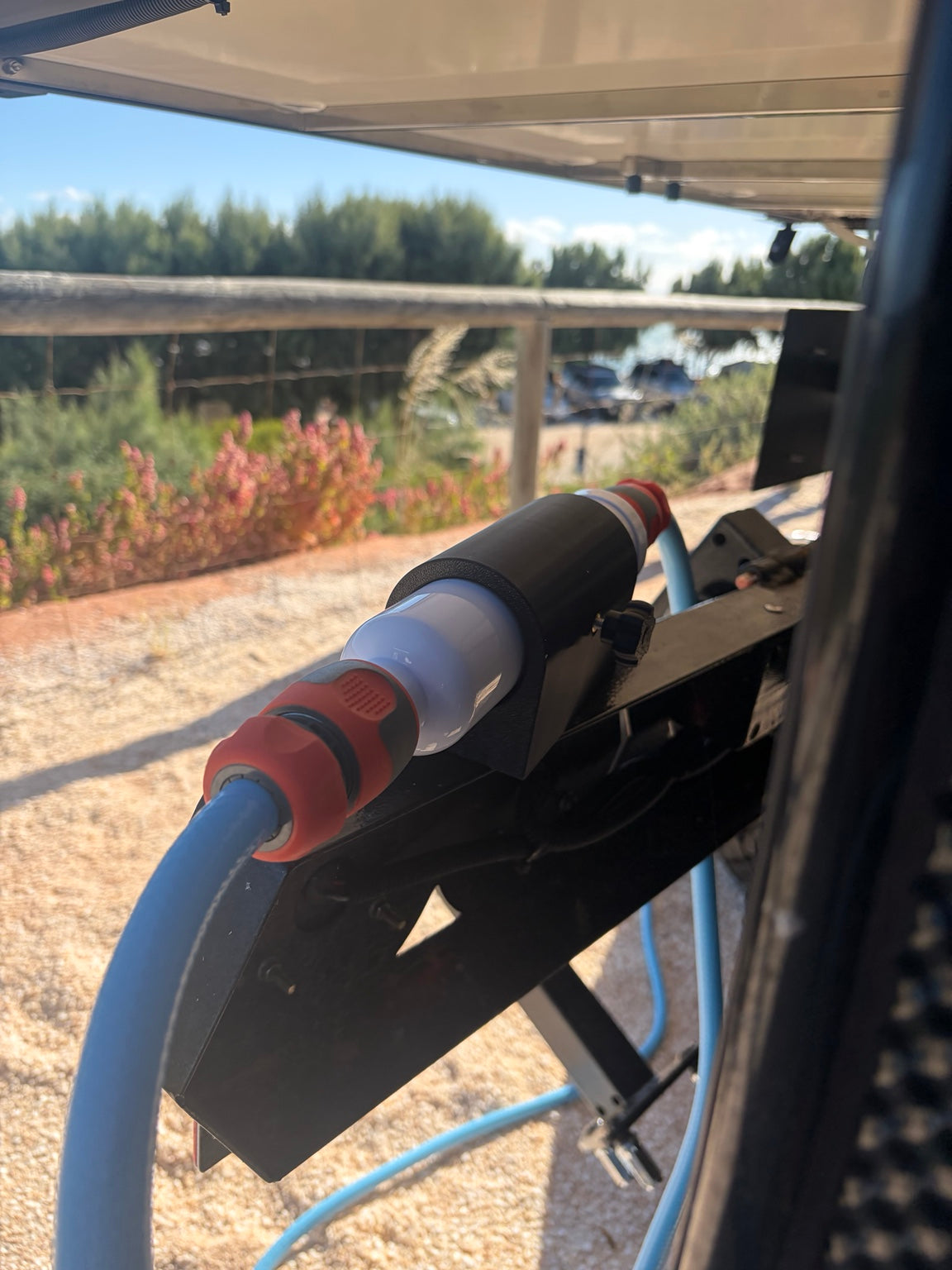 Close-up of the magnetic inline water filter holder and adjustment knob mounted on a caravan